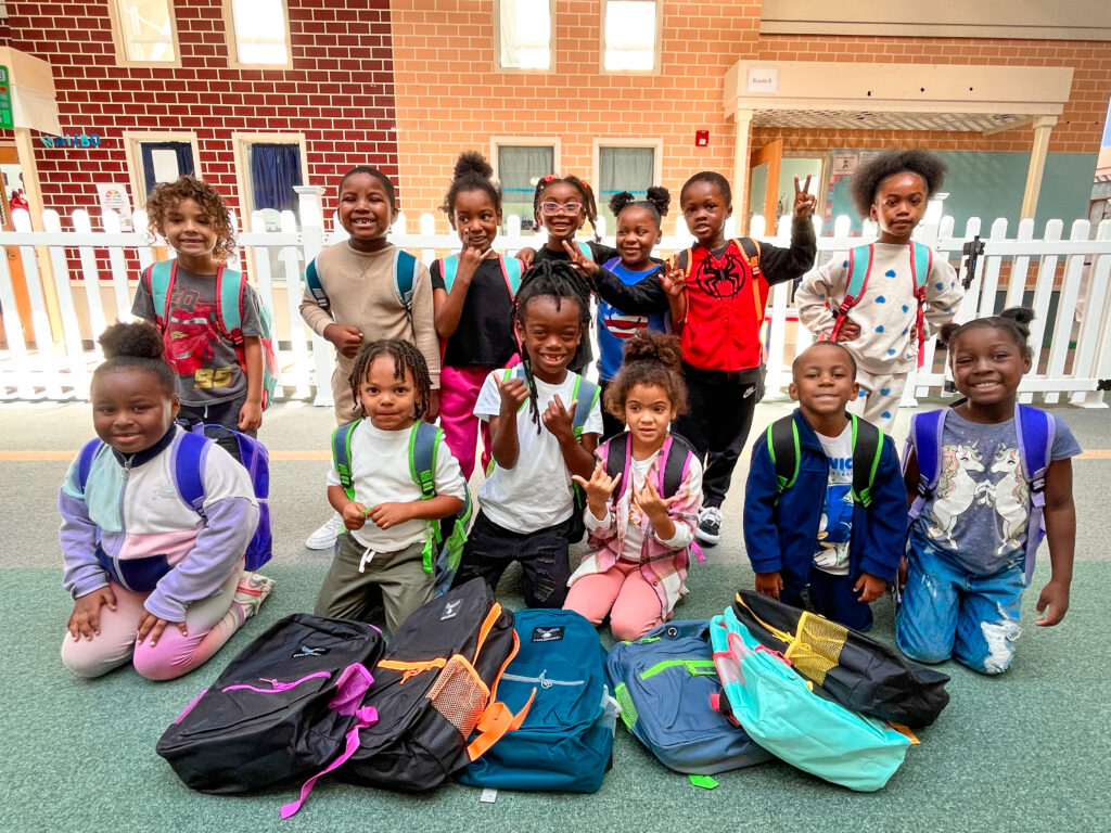 preschool class posing with their new backpacks
